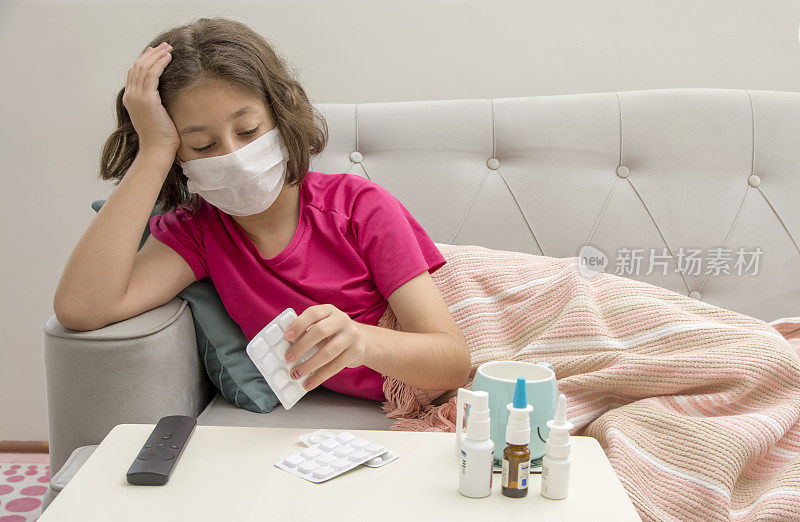 生病的年轻女孩躺在床上发高烧。Covid - 19和Cold flu库存照片